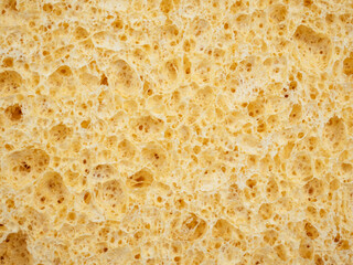 Cosmetic sponge texture background. Natural color cleaning sponge material detail. Close up, macro view. Dish washing or beauty care.