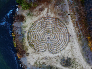 Spiral labyrinth made of stones on the cost, top view from drone