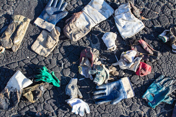 a lot of dirty gloves after repairing a soft bituminous roof in the attic