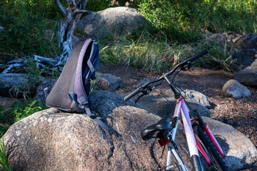 Bicycle and backpack on a rock on the lake shore