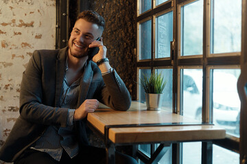 Happy young businessman with mobile phone