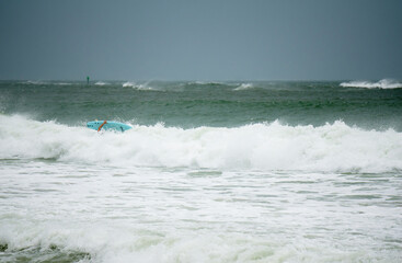 A surfer braves the high surf during tropical storm ETA on St. Pete Beach, Florida
