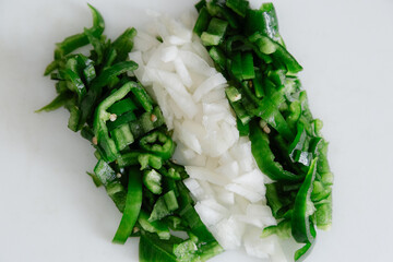 Bell pepper and onion cut with a knife to prepare a meal