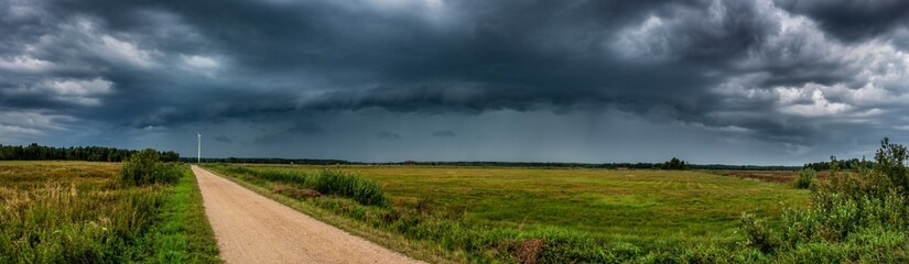 Dramatic view of a shelf cloud over a field, horizontal cloud formation, panorama view.
