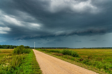 Fototapeta na wymiar Dramatic view of a shelf cloud over a field, horizontal cloud formation, panorama view.