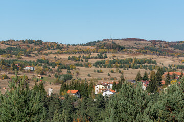 Beautiful scenery in autumn Bulgarian mountain village trees blue sky background on hillside