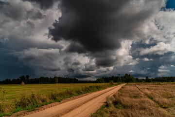 Fototapeta premium Dramatic view of a shelf cloud over a field, horizontal cloud formation, panorama view.