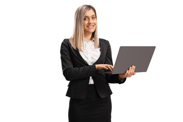 Young blond businesswoman standing and working on a laptop computer