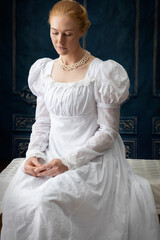 A regency woman wearing a white muslin dress 