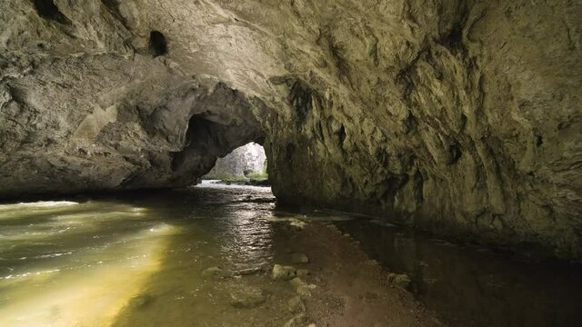 Beautiful Stream Flows Through Underground Cave With Flooded Path Leading Outside.