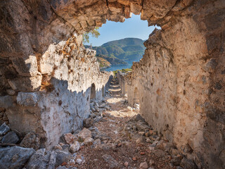 view to blue sky through hole in wall of antique stone tunnel