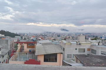 Fototapeta premium view point from a rooftop in the city in a cloudy day with mist covering the buildings 