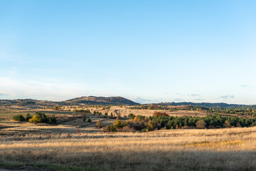 Colorful autumn trees golden field clear blue sky background rural hillside view