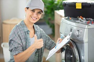 young woman repairing washing machine