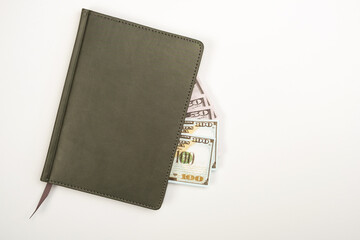 On the desktop is a diary and money invested in the diary.