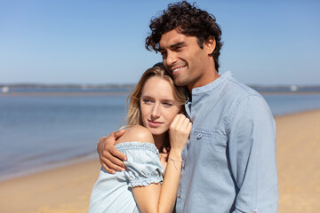 Fototapeta premium attractive couple snuggled together on the beach