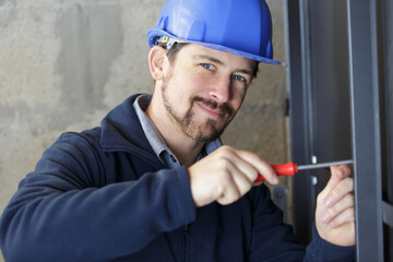 senior man fitting a pvc window with screwdriver