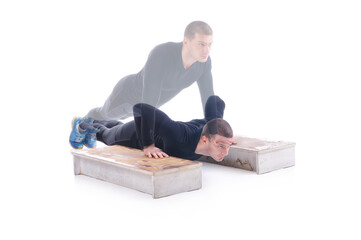 Concentrated young sportsman exercising and doing push ups on the wooden stairs. White background....
