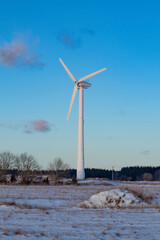 Wind turbine power generator on a field in winter