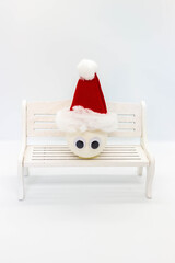 Snowman made of a ball on a banch on white background.Winter Christmas Holiday concept