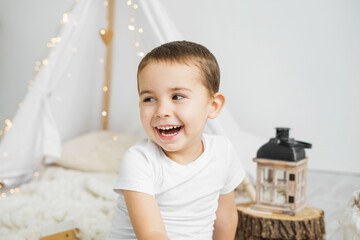Little caucasian boy laughing in a christmas scandinavian interior.