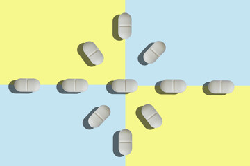 Top view of a group of rounded pills on a blue and yellow background