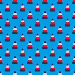 Seamless pattern of many knitted tricolor hats on a blue background