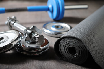 Obraz na płótnie Canvas Dumbbell discs barbell and mat for home sports