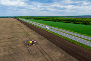self-propelled sprayer in the field makes fertilizers in early spring, backlit jet
