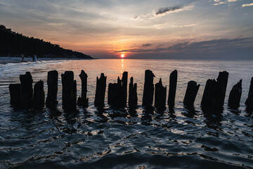 Sunset over breakwater on a beach in Debki resort village on the Baltic Sea coast in Pomerania region of Poland