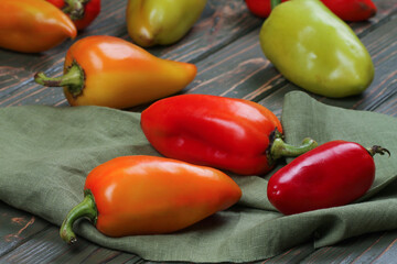Orange, green, red peppers on a wooden table. Vegetables.