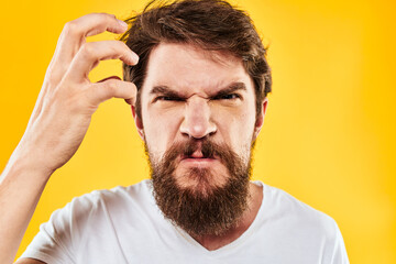 Obraz premium emotional bearded man gesturing with hands aggression discontent close-up yellow background