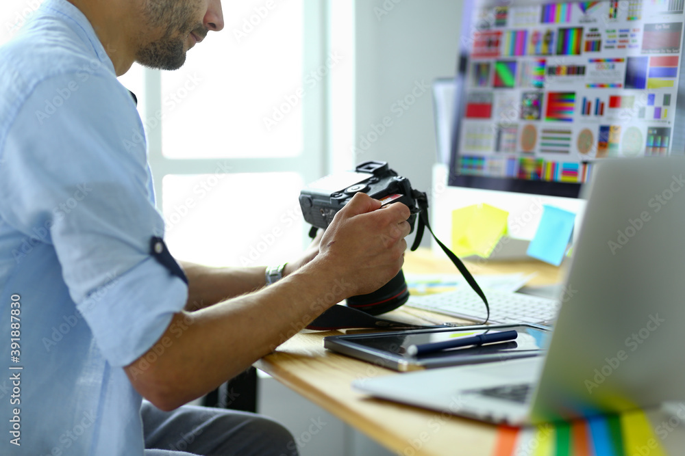Poster portrait of young designer sitting at graphic studio in front of laptop and computer while working o