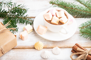 Christmas or New Year composition. Decorations, box, balls, fir and spruce branches, cup of coffee, on a white wooden background. Side view, copy space, selective focus.