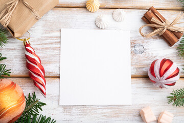 Christmas or New Year frame composition, template. Decorations, box, balls, fir and spruce branches, cup of coffee, on a white wooden background. Top view, copy space.