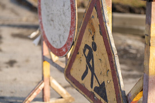 Close up of sign of road work to inform traffic participants about carrying out repairs on road. Concept of careful and attentive driving.