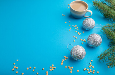 Christmas or New Year composition. Decorations, silver balls, fir and spruce branches, on a blue background. Side view, copy space.