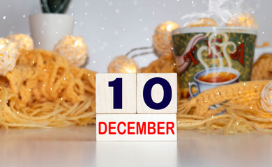 White block calendar present date 10 and month December on wood background