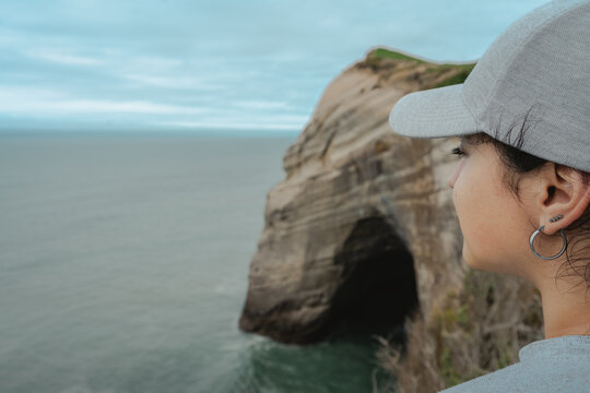 Close up of woman face at amazing cliff landscape at Cape Farewell, New Zealand