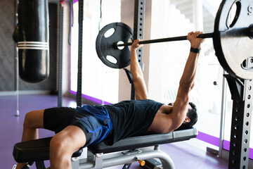 Young man lifting weights with a barbell