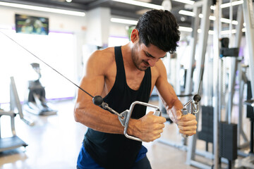 Latin man working out on a cable machine