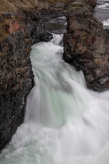 Close-up of Smooth River Waterfall with Rocky Coastline