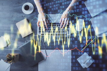 Multi exposure of woman hands working on computer and forex chart hologram drawing. Top View. Financial analysis concept.