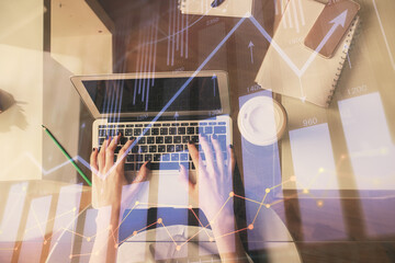 Double exposure of woman hands working on computer and forex chart hologram drawing. Top View. Financial analysis concept.