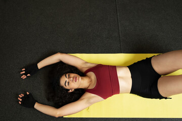 Latin young woman resting and stretching on a mat