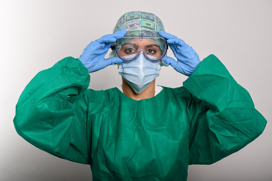 Enfermera protegida con traje (EPI), gafas y mascarilla, se ajusta las gafas