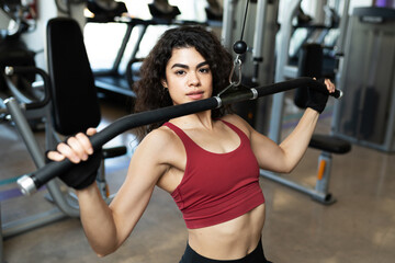 Fototapeta na wymiar Pretty hispanic woman with curly hair at the gym