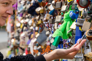 Fototapeta na wymiar Woman in love locking love padlock on famous bridge Pont des Arts, Paris, France. Couple goal, travel and lifestyle concept. 