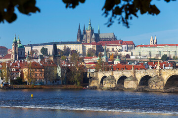 Autumn colorful Prague Lesser Town with gothic Castle and Charles Bridge above River Vltava in the...