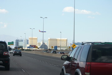 Las Vegas city entrance landscape with cars on freeway and airplane